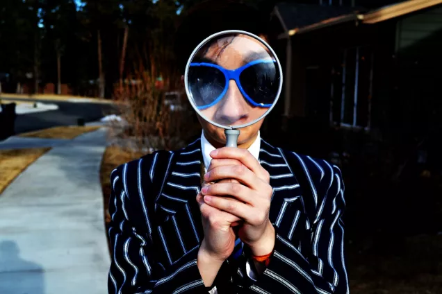 A young woman holding a magnifying glass. Photo. 